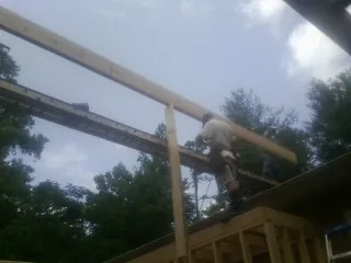 Carpenter setting a ridge beam over a new addition frame — Ice Dam Removal by Roofing Brothers in Fort Plain