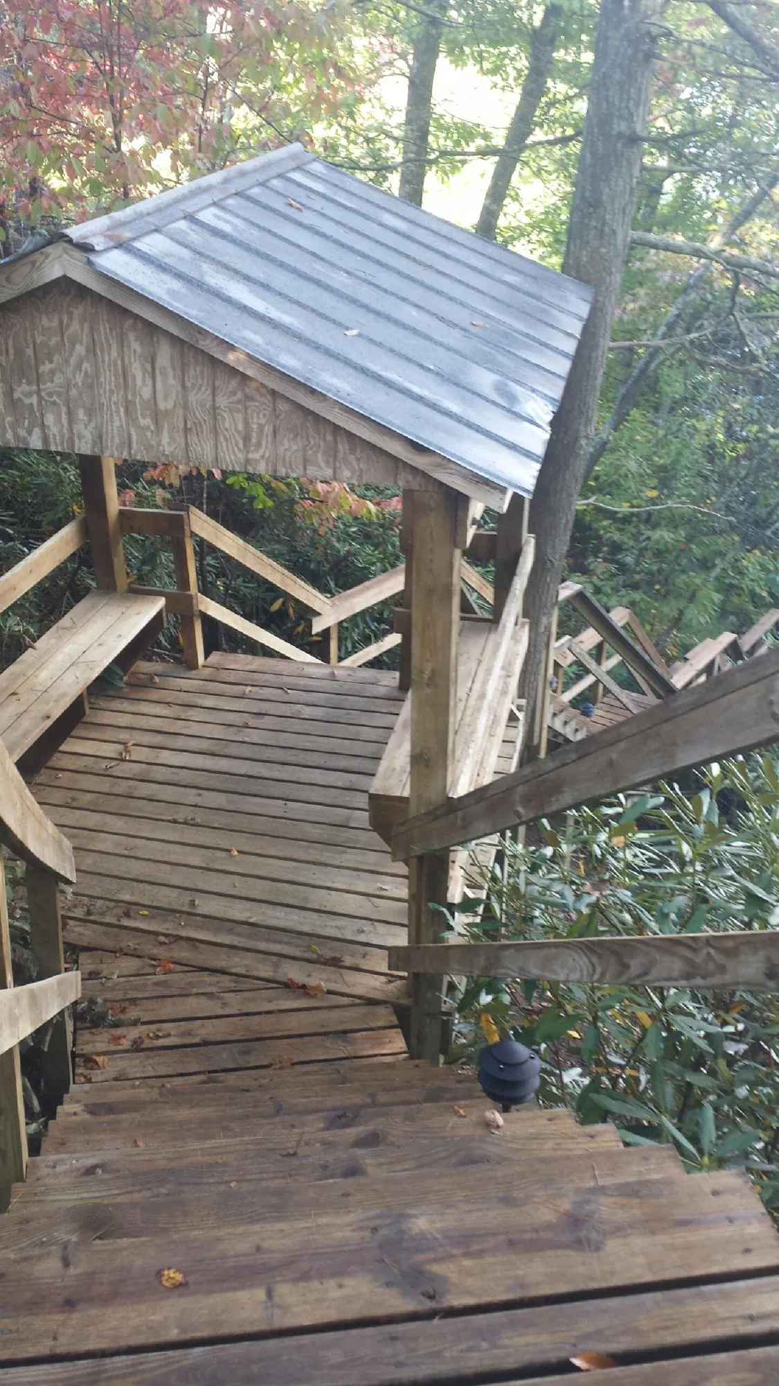 Metal roofed shelter over wooden steps on a wooded walkway — Skylight Repair & Installation work by our crew in Fort Plain