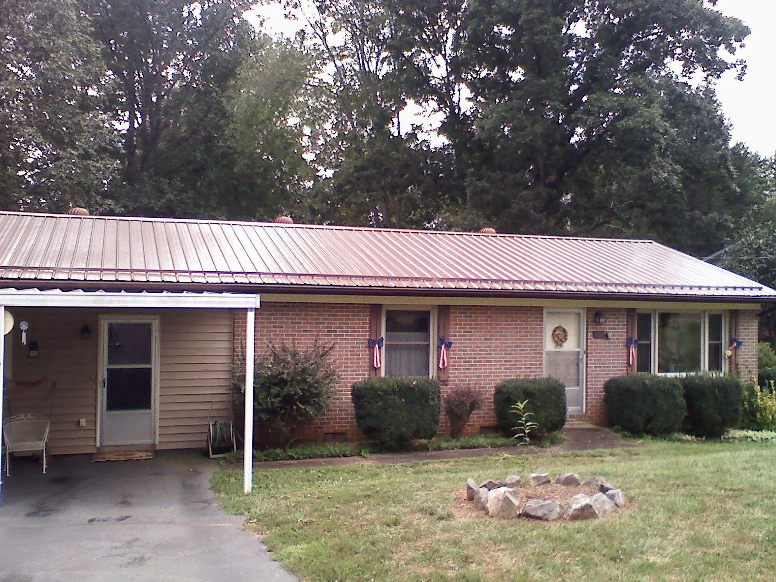 Bronze metal roof and carport on a brick ranch home — Roof Repair work by our crew in Fort Plain